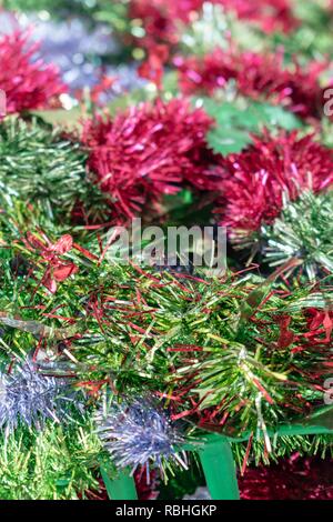 Close up of a variety of Christmas decorative tinsel in mainly red and green colors. Close up macro overhead image Stock Photo