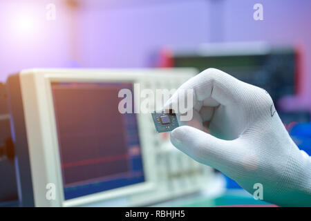 Hand with small electronic microchip microcontroller Stock Photo