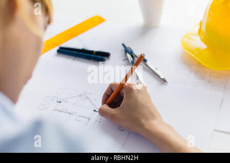 Architect drawing blueprints. Close up of construction engineer working on the project Stock Photo