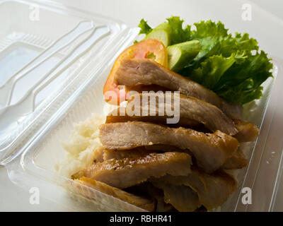 Roasted pork and rice in a transparent plastic box packaging Stock Photo