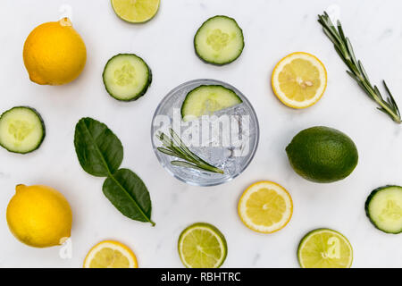 Gin tonic cocktail drink glass with ice cucumber lime lemon white background Stock Photo