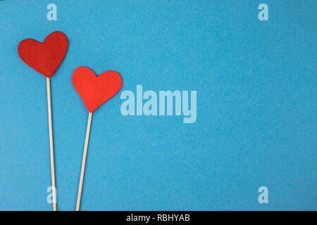 Two felt hearts on a blue background. Stock Photo