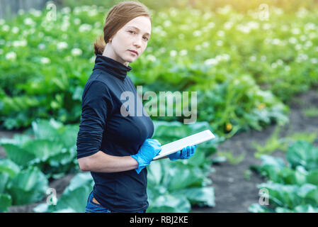 Woman specialist agronomist holding a tablet in hand. The concept of agricultural farms and quality control Stock Photo