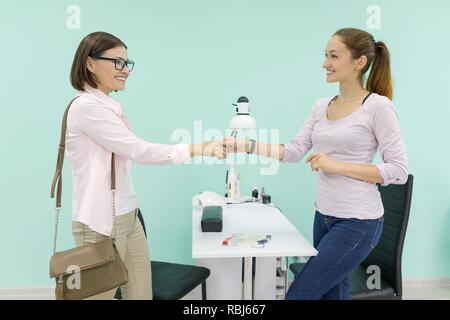 Women manicurist and client shake hands in the salon for the care of hands and nails. Stock Photo