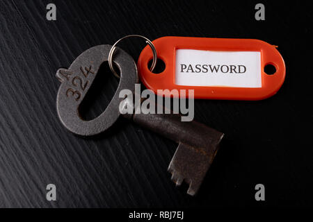 An old key with an inscription on a black table. Accessories and symbol referring to the word in the description of the key. Black background. Stock Photo