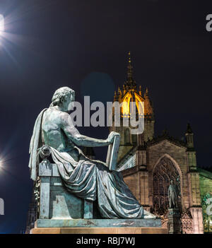 David Hume statue by Alexander Stoddart lit at night with St Giles Cathedral, Royal Mile, Edinburgh, Scotland, UK Stock Photo