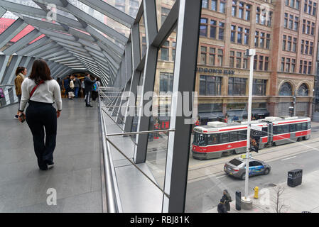 A traam on Queen Street seen from inside the Helix Sky Bridge that links the Eaton Centre to the Hudson Bay Building, Toronto , Canada Stock Photo