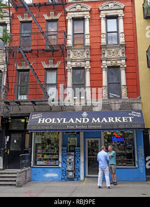 Two men outside Holyland Market, 122 St Marks Place, East Village, New York, NYC, NY, USA Stock Photo