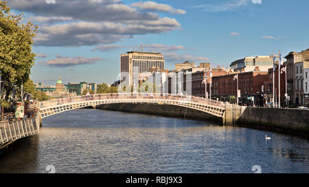 People walk over the Ha'penny Bridge over the Liffey River in Dublin, Ireland. Stock Photo