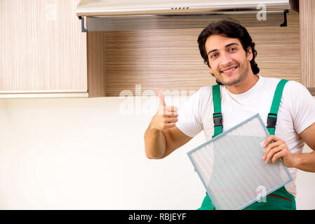 Young contractor repairing air-conditioner in kitchen Stock Photo