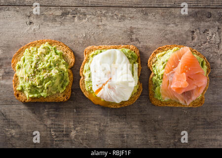 Toasted breads with avocado, poached eggs and salmon. Top view. Stock Photo