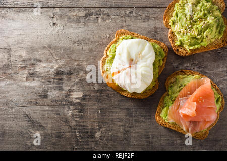 Toasted breads with avocado, poached eggs and salmon. Top view. Copyspace Stock Photo