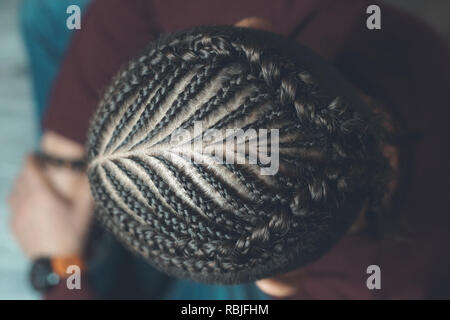 The back of a man braided into thin braids, a creative hairstyle Stock Photo