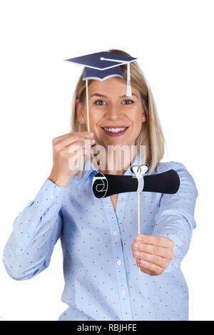 Confident young woman holding university diploma and academic cap, smiling to the camera on isolated background Stock Photo