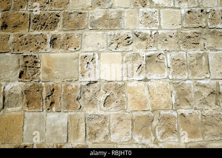 Vintage antique wall from old sandy limestone as background front view closeup Stock Photo