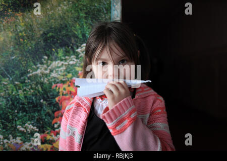 Portrait of a young Ukrainian girl playing with a paper plane during class breaks at school. Radinka, Polesskiy district,Kiev Oblast, northern Ukraine Stock Photo