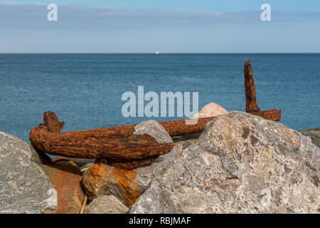 Old rusty anchor on the rocks at Beesands Stock Photo