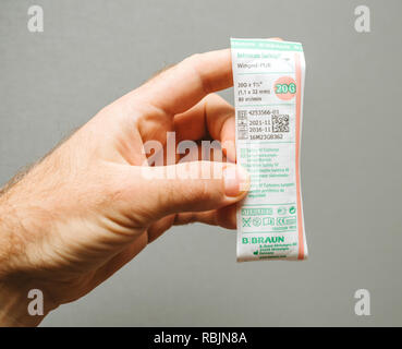 PARIS, FRANCE - NOV 22, 2017: Male Doctor holding in hand Safety Catheter IV made by Braun Melsungen AG - rear view of object  Stock Photo