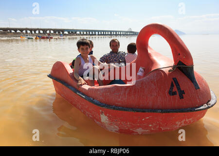 A man is riding a pedal boat with his children on the Urmia Lake, West Azerbaijan province, Iran Stock Photo