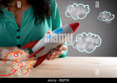 Businesswoman launches his company with a rocket. Concept of startup and innovation Stock Photo