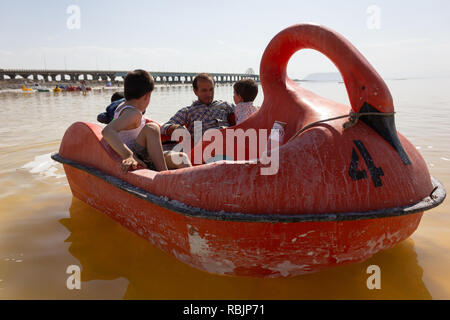 A man is riding a pedal boat with his children on the Urmia Lake, West Azerbaijan province, Iran Stock Photo