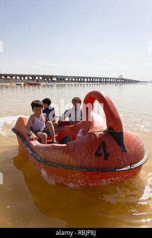 A man is riding a pedal boat with his children on the Urmia Lake, West Azerbaijan province, Iran Stock Photo
