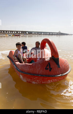 A man is riding a pedal boat with his children on the Urmia Lake, West Azerbaijan province, Iran Stock Photo