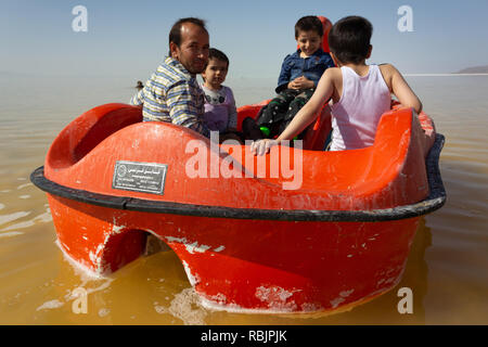 A man is riding a pedal boat with his children on the Urmia Lake, West Azerbaijan province, Iran Stock Photo