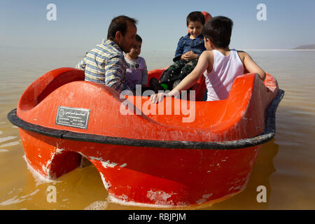 A man is riding a pedal boat with his children on the Urmia Lake, West Azerbaijan province, Iran Stock Photo