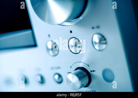 Steel Brushed aluminum front panel with multiple buttons and knobs of a digital amplifier radio CD player Stock Photo
