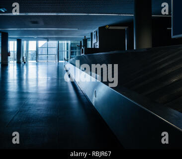 Solitude in the empty airport hall with no lugaage on conveyor belt blue toned image Stock Photo