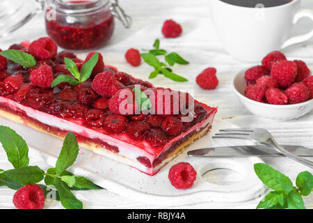 raspberry cake with fresh berries and mint on white wooden table. sweet dessert for breakfast. close up Stock Photo