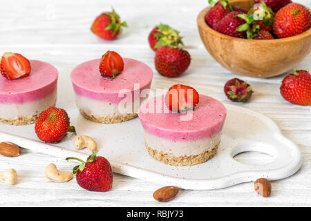 vegan raw strawberry and banana cakes with fresh berries and nuts. healthy delicious food Stock Photo