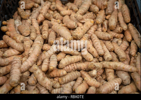 close up of Tumeric roots in a basket for sale in a market. Stock Photo