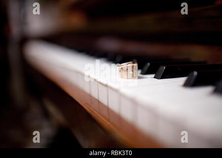 Close-up of a pair of wedding rings on the piano keys Stock Photo