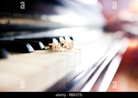 Close-up of a pair of wedding rings on the piano keys Stock Photo