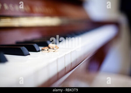 Close-up of a pair of wedding rings on the piano keys Stock Photo