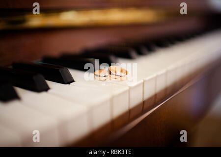 Close-up of a pair of wedding rings on the piano keys Stock Photo