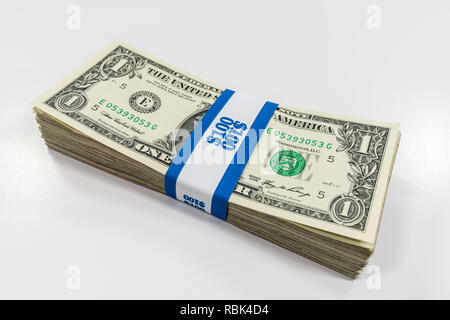 Pack of one dollar bills wrapped with $100 paper currency strap. Stock Photo