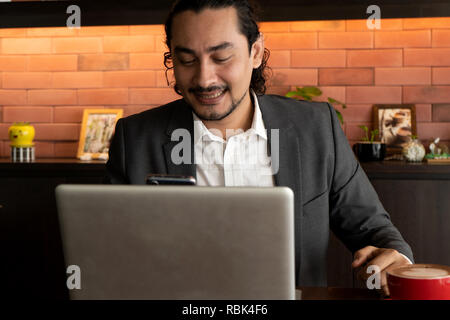Young Asian Indian businessman using tablet pc at cafe Stock Photo