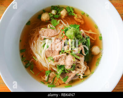 delicious noodles bowl / close up of rice noodles soup with meatball liver pork stew and vegetable in bowl traditional thai and chinese style food of  Stock Photo