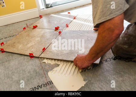 Man Laying Piece Of Square Tile On Adhesive Stock Photo