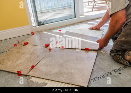 Man Laying Square Tile On Adhesive Stock Photo