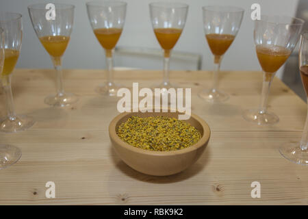 Pollen from Bees:  Grains in a Round Wooden Bowl and Around Glasses with Various Types of Honey. Stock Photo