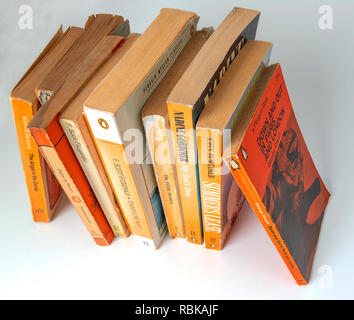 Collection of Penguin paper back books gathering dust from being left on a book shelf  for 20 years . Stock Photo