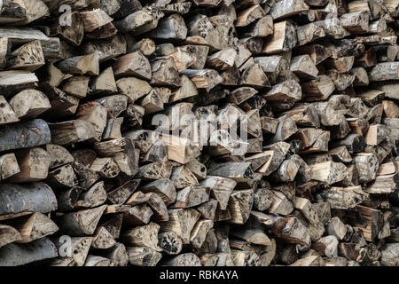 Natural wood background, logs of chopped firewood are stacked in a row Stock Photo