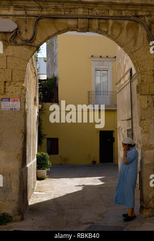 On the 'phone, Arco Vecchio, Via Balbo Quinto Fabio, Lecce Puglia, Italy Stock Photo