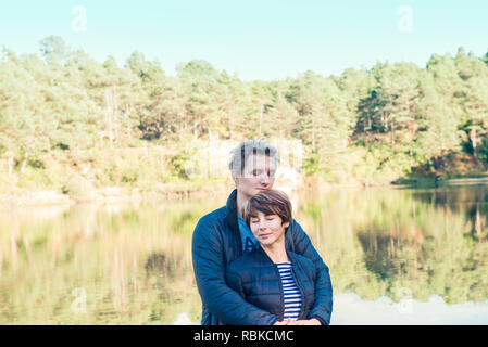Two attractive dreamy people, couple in casual outfit at wild forest near water. Idyllic calm peaceful life style person freedom concept. Selective fo Stock Photo