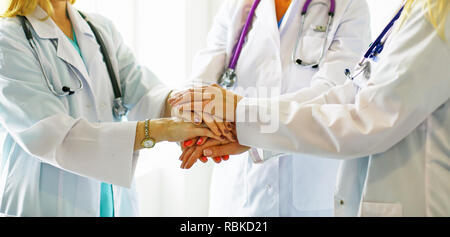 Doctors and nurses in a medical team stacking hands. Stock Photo