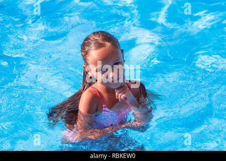 Beautiful little girl swims in the pool , cute little girl in pool in ...